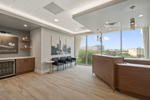 a modern dental office front desk with a large window and a bar.